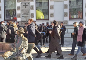 Maturzyści tańczą poloneza na ulicy Piotrkowskiej a w tle widać orkiestrę