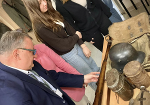 Pan dyrektor wraz z uczniami oglądają eksponaty