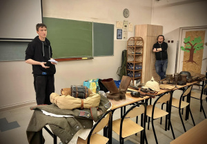 Prezentacja w sali lekcyjnej uczeń pokazuje przyniesiony ekwipunek