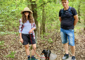 Na zdjęciu pani Marta Piotrowska Pan Wojciech Faryński i pies jamnik w lesie w Łagiewnikach