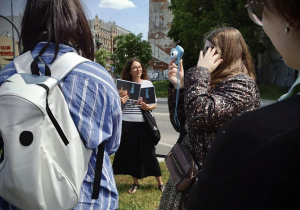 Pani profesor Piotrowska opowiada Łódzkich neonach pokazując zdjęcie neonu przy ulicy Sienkiewicza