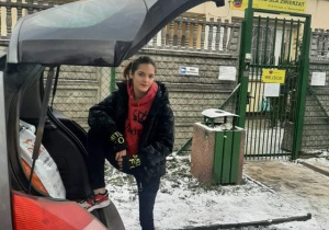 Uczennica klasy 3MG Maja Dudek przy samochodzie z prezentami dla schroniska